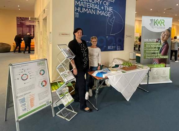 Präsentationsstand des Klinischen Krebsregisters beim Tumortag in Dessau. Zwei Frauen stehen bei dem Stand um Interessierte über die Arbeit des KKR zu informieren.